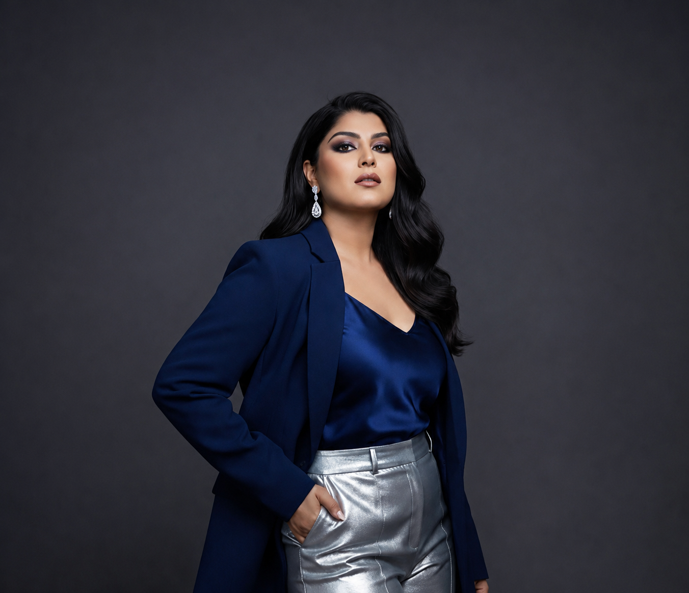 Amna Inam, International Designer and Stylist, portrait in navy blazer and silver trousers